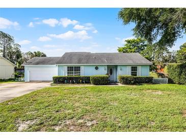 Charming light blue one-story home with a well-manicured front yard and lovely landscaping at 8121 Via Bonita, Sanford, FL 32771