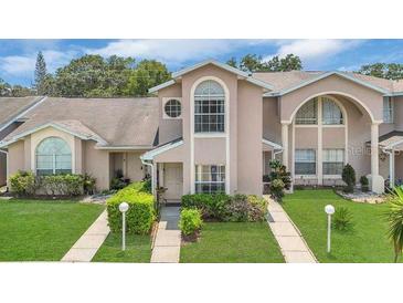 Charming townhome with manicured lawn and inviting facade with unique architectural detail at 1642 Windsor Oak Ct, Kissimmee, FL 34744