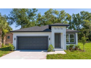 Charming single-Gathering home featuring a two-car garage, well-maintained landscaping, and modern architectural details at 33 W 7Th St, Apopka, FL 32703