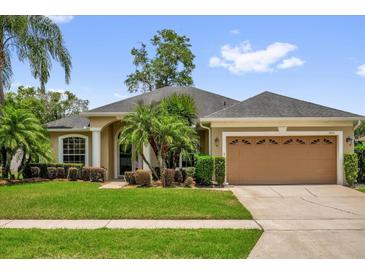 Charming single-story home with a well-manicured lawn, lush landscaping, and an attached two-car garage at 3304 Bennington Ct, Winter Park, FL 32792