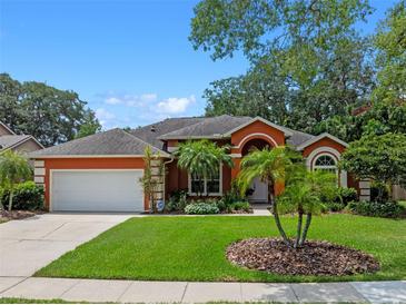 Charming one-story home with a beautiful front lawn, palm trees, and an attached two-car garage at 3518 Edlingham Ct, Belle Isle, FL 32812