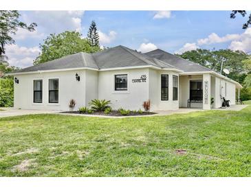 Charming single-story home with stucco exterior, black-framed windows, and well-manicured lawn at 455 Orange Ave, St Cloud, FL 34769