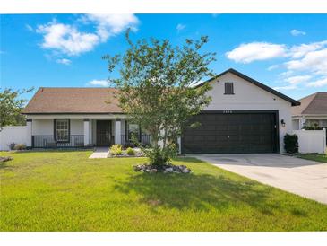Charming single-story home featuring a well-manicured lawn and a two car garage at 2406 Placid Way, Kissimmee, FL 34758