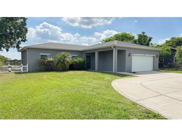 Charming single-story home featuring a well-manicured lawn and attached two-car garage at 344 Buenaventura Blvd, Kissimmee, FL 34743
