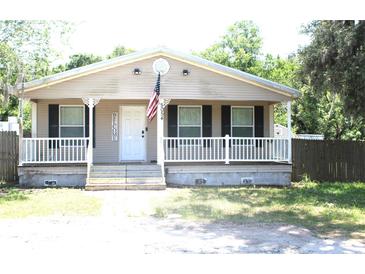 Charming single-story home featuring a covered front porch, a welcoming entrance, and neatly landscaped surroundings at 5054 Mcdonald Rd, Zellwood, FL 32798
