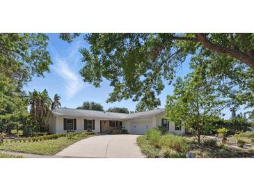 Charming single-story home features a stone accent wall, a wide driveway, and lush, mature landscaping at 6327 Ridgeberry Dr, Orlando, FL 32819