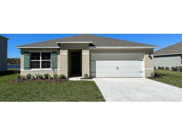 Charming single-story home featuring a pristine two-car garage and neatly landscaped front yard under a clear blue sky at 1000 Ellerston St, Daytona Beach, FL 32124