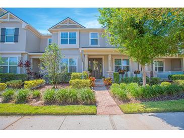 Charming townhouse with well-manicured landscaping, brick walkway, and a welcoming front porch at 10520 Burrows St, Orlando, FL 32832