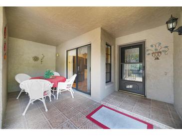 Charming covered patio with tile flooring, a dining table, and access to the unit's entrance at 1074 Kensington Park Ct # 101, Altamonte Springs, FL 32714