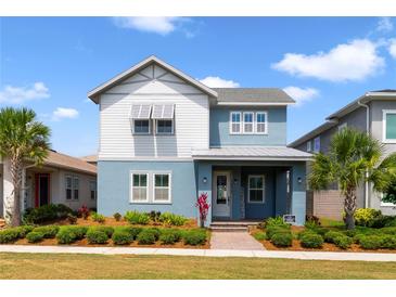 Charming two-story home featuring a landscaped yard, two tone exterior, and inviting front porch at 14525 Englert Aly, Orlando, FL 32827