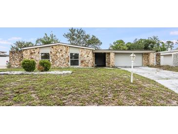 Charming single-story home featuring stone accents, an attached garage, and a well-manicured front yard at 1470 Winston Rd, Maitland, FL 32751