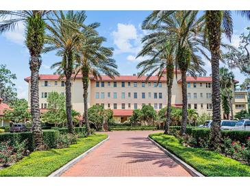 Stately building with red tiled roof, palm trees and inviting walkway at 1602 Alabama Dr # Ph404, Winter Park, FL 32789