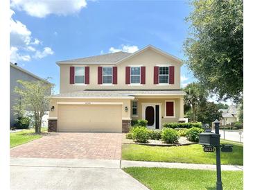 Charming two-story home with a brick-paved driveway, well-manicured lawn and front garden at 16334 Saint Augustine St, Clermont, FL 34714