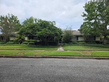 Charming single-story home with lush landscaping and mature trees lining the front yard at 2817 Fitzooth Dr, Winter Park, FL 32792