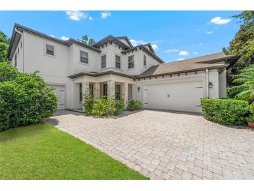 Elegant two-story home featuring a stone-accented entrance, three-car garage and meticulously paved driveway at 808 Sherbourne Cir, Lake Mary, FL 32746