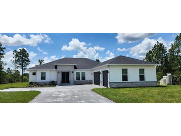 Beautiful single-story home featuring a stone facade, manicured lawn, and attached two-car garage at 160 Steeplechase Cir, Sanford, FL 32771