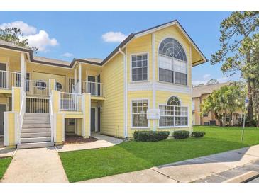 Charming yellow condo with well-manicured lawn and covered entryway at 2040 Royal Bay Blvd # 31, Kissimmee, FL 34746