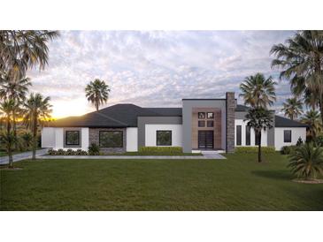 Modern single-story home featuring clean lines, stone accents and professional landscaping with palm trees at 26019 Estates Ridge Dr, Sorrento, FL 32776