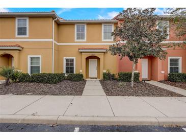 Charming townhome with a colorful exterior, well-maintained landscaping, and inviting front entrance at 3019 White Orchid Rd, Kissimmee, FL 34747