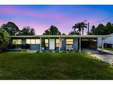 Charming single-story home featuring a well-maintained lawn and stylish curb appeal enhanced by an attached carport at 5384 Barton Dr, Orlando, FL 32807