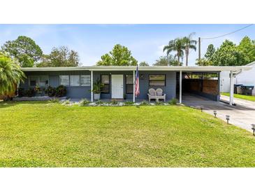 Lovely one-story home featuring an open carport, tidy lawn, and welcoming front porch at 5384 Barton Dr, Orlando, FL 32807