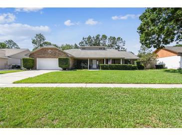 Charming brick ranch home with a lush green lawn and well-maintained landscaping at 7618 Majestic Pine Ct, Orlando, FL 32819