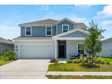 Charming two-story home with a well-maintained lawn and a two-car garage on a sunny day at 1209 Deepwater Cir, Eagle Lake, FL 33839