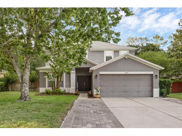 Charming two-story home with a gray exterior, well-manicured lawn, and a two-car garage at 1245 Reagans Reserve Blvd, Apopka, FL 32712
