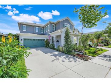 Charming two-story home with a well-manicured lawn, teal garage door, and welcoming front porch at 13822 Darchance Rd, Windermere, FL 34786