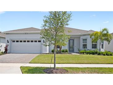 Charming single-story home featuring a well-manicured lawn and a two-car garage at 15049 Canopy Cover Dr, Winter Garden, FL 34787