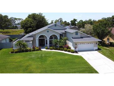 Beautiful single-story home boasts a manicured lawn and well-maintained landscaping at 1676 Bear Crossing Cir, Apopka, FL 32703
