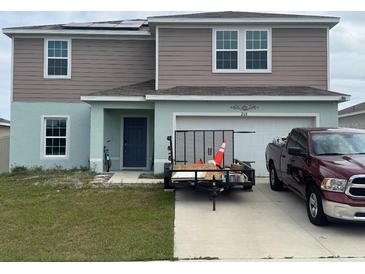 Charming two-story home featuring a spacious front yard and attached garage at 268 Fiddlewood Ct, Davenport, FL 33837