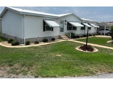 Charming single-story home with well-maintained lawn, awnings, and tasteful landscaping at 361 Dreama Dr, Davenport, FL 33897