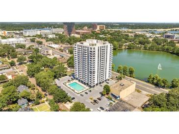 Stunning aerial view of high-rise condo featuring a pool, well-manicured landscaping, and beautiful lake views at 400 E Colonial Dr # 1609, Orlando, FL 32803