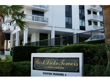 Elegant condominium building featuring a sign, lush landscaping and visitor parking access at 400 E Colonial Dr # 1609, Orlando, FL 32803