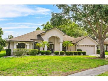Charming home featuring a well-manicured lawn, mature trees, and attractive landscaping at 4905 Emilee Grace Ln, St Cloud, FL 34771
