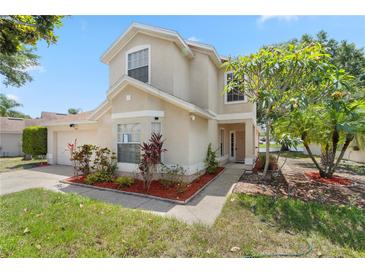 Charming two-story home with a well-maintained lawn, vibrant landscaping, and a welcoming entrance at 9145 Fort Jefferson Blvd, Orlando, FL 32822