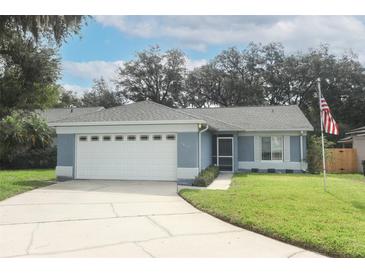 Charming single-story home featuring a well-manicured lawn, attached two-car garage, and inviting entrance at 1077 Dees Dr, Oviedo, FL 32765