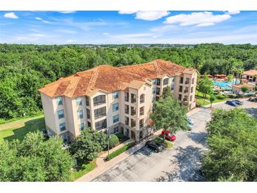 Stunning condo building featuring a terracotta roof with lush surroundings and convenient parking at 1375 Tuscana Ln # 1102, Davenport, FL 33896