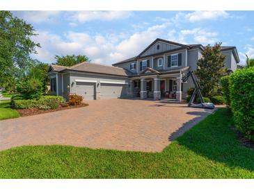 Beautiful two-story home boasts a paver driveway, three-car garage, and well-manicured landscaping at 14357 United Colonies Dr, Winter Garden, FL 34787