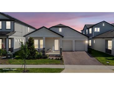 Charming single-story home featuring a cozy front porch, two-car garage, and beautifully landscaped front yard at 16055 Silver Brook Way, Winter Garden, FL 34787