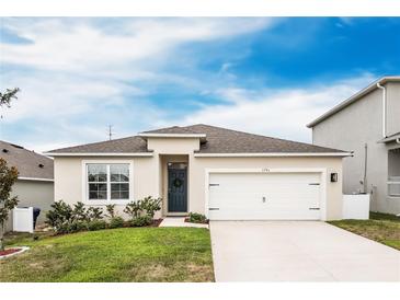 Charming one-story home featuring a well-manicured lawn, two-car garage, and a welcoming front door at 1791 Hackberry St, Clermont, FL 34715
