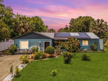 Charming single-story home featuring a well-manicured lawn and solar panels for energy efficiency at 1872 Wayside Dr, Orlando, FL 32818