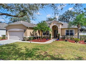 Charming single-story home with a well-manicured lawn, lush landscaping, and a two-car garage at 1913 Lazy Oaks Loop, St Cloud, FL 34771