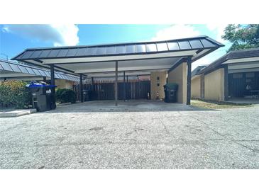 Carport area of a residential property, featuring parking and adjacent residential building exteriors at 2235 Silver Pines Pl # 401, Orlando, FL 32808