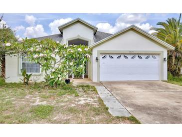 Charming single-story home featuring a white garage door, well-kept lawn, and beautiful flowering shrub in the front yard at 3029 Bransbury Ct, Kissimmee, FL 34747