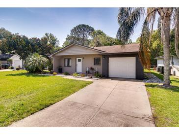 Charming single-story home with a well-manicured lawn, mature trees, and a private driveway at 5216 Sunrise Blvd, Orlando, FL 32803