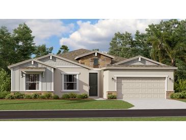 Beautiful one-story home with stone accents, a well-manicured lawn, and an attached two-car garage at 773 Tundra Loop, Groveland, FL 34736