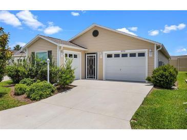 Charming single-story home featuring an attached garage, well-maintained lawn, and mature landscaping at 6231 Atkinson Ln, The Villages, FL 32163