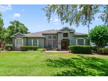 Charming single-story home with lush front lawn and attractive landscaping under a cloudy sky at 1515 Cherry Lake Way, Lake Mary, FL 32746